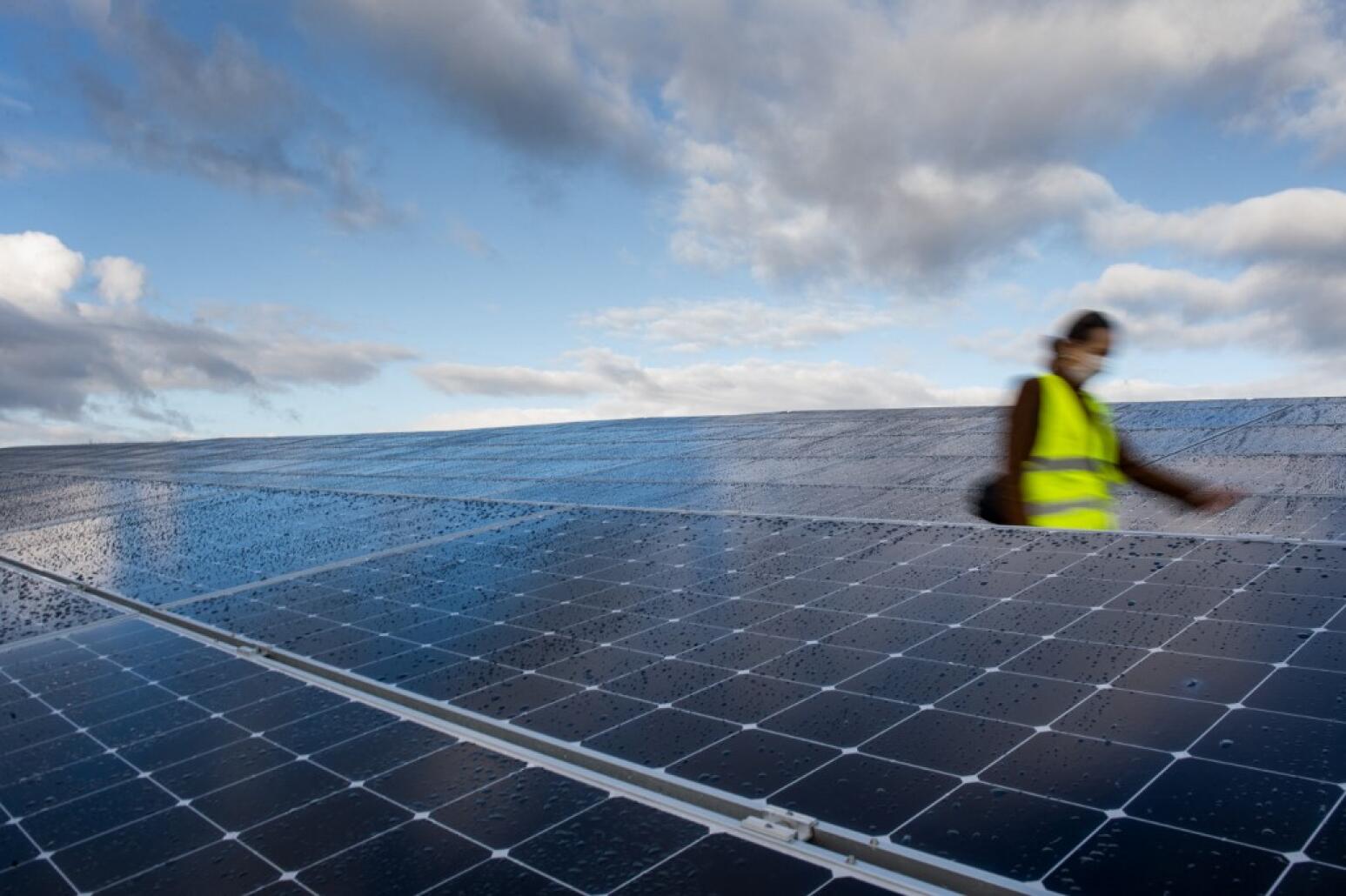 Une femme parmi les panneaux photovoltaïques à Guignen - France - Radio nova © Loic VENANCE / AFP