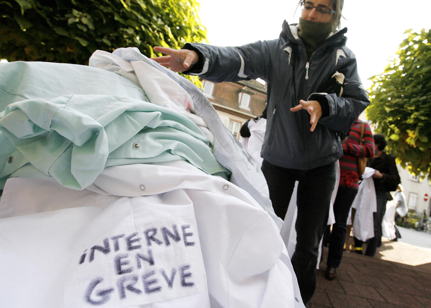 Des internes en médecine déposent leurs blouses blanches sur un cercueil factice symbolisant la Sécurité Sociale, le 22 octobre 2007 devant la Mairie de Lingolsheim, pour protester contre le rétablissement, le 17 octobre dernier à l'Assemblée nationale de deux articles du projet de loi restreignant la liberté d'installation des médecins libéraux. AFP PHOTO OLIVIER MORIN (Photo by OLIVIER MORIN / AFP)